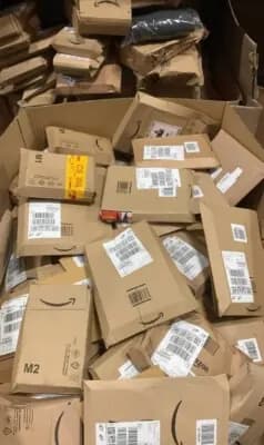 Pila de cajas Amazon con cinta Prime original recibidas en almacén